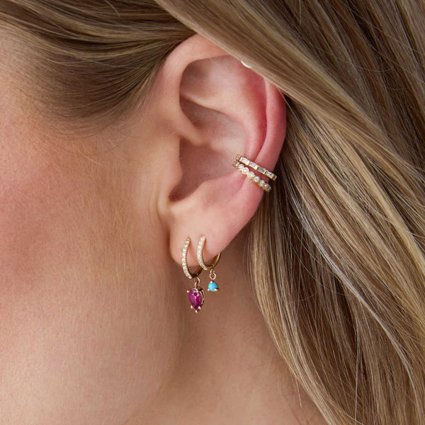 woman's ear wearing a Zoë Chicco 14k Gold Medium Pavé Diamond Hinge Huggie Hoop with Pear Ruby and a14k Dangling Turquoise Small Pavé Diamond Hinge Huggie Hoop in her second piercing with a Baguette Diamond Eternity Ear Cuff and a Diamond Bezel Ear Cuff 