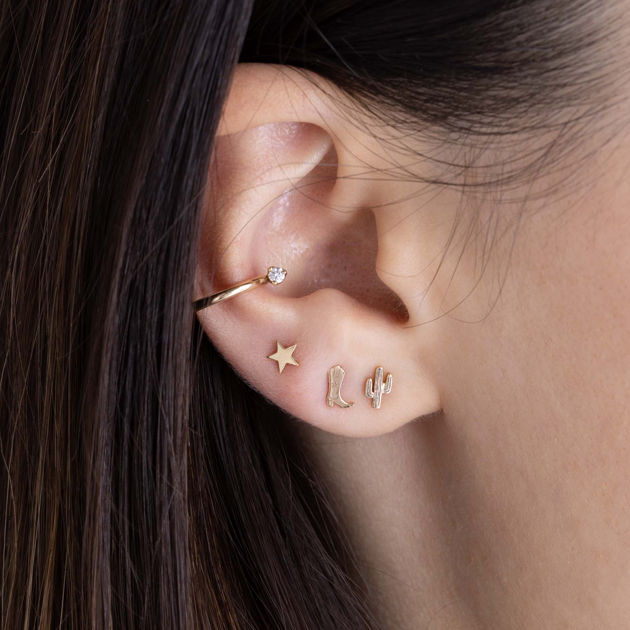 woman's ear wearing a ZoÃ« Chicco 14k Gold Itty Bitty Cowboy Boot Stud Earring in her second piercing layered with an Itty Bitty Star and Itty Bitty Cactus Stud