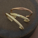 Zoe Chicco's 14k Wide Pyramid Cuff, 14k Wide Pavé Diamond Knife Edge Cuff, and 14k Pavé Diamond Line Knife Edge Cuff on a brown background.