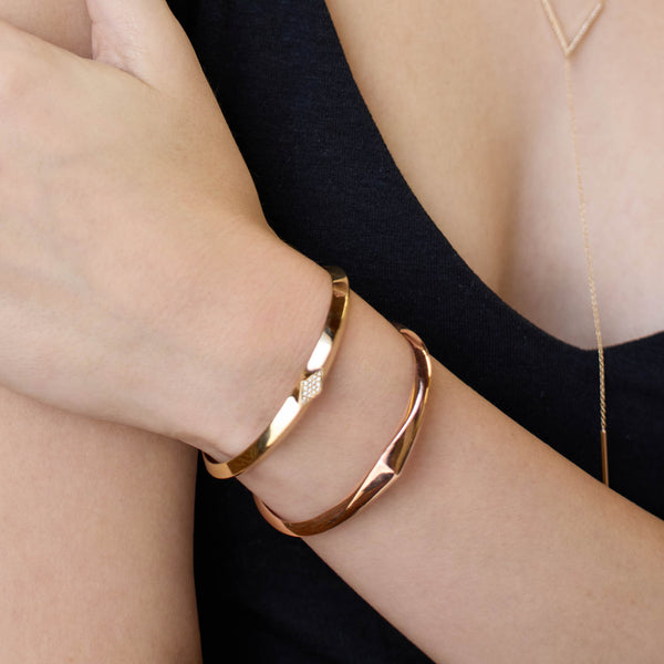 Zoe Chicco 14k gold and rose gold geometric bracelets on a girls wrist on a dark background