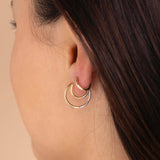 A model is wearing Zoe Chicco's 14k Two Tone Gold Reversible Hinge Huggie Hoops in size 17mm, 12mm and 10.5mm up the ear.