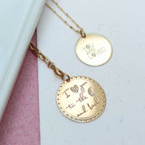a close up of a Zoë Chicco 14k Gold Large Pavé Diamond "I love you to the moon and back" Disc Charm Pendant on a chain laying flat with a  Medium "YOU ARE LOVED" with Diamonds Disc Charm