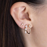 woman's ear wearing a Zoë Chicco 14k Gold 3 Linked Pear Diamond Drop Earring in her second piercing layered  with a 14k Pear Diamond Large Hinge Huggie Hoop and a 14k Short Diamond Ice Pick Stud