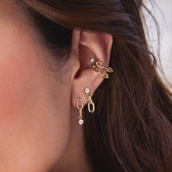 close up of a woman's ear wearing two versions of the Zoë Chicco 14k Gold Prong Diamond & Large Square Oval 2 Link Drop Earrings layered with two square oval link chain ear cuffs