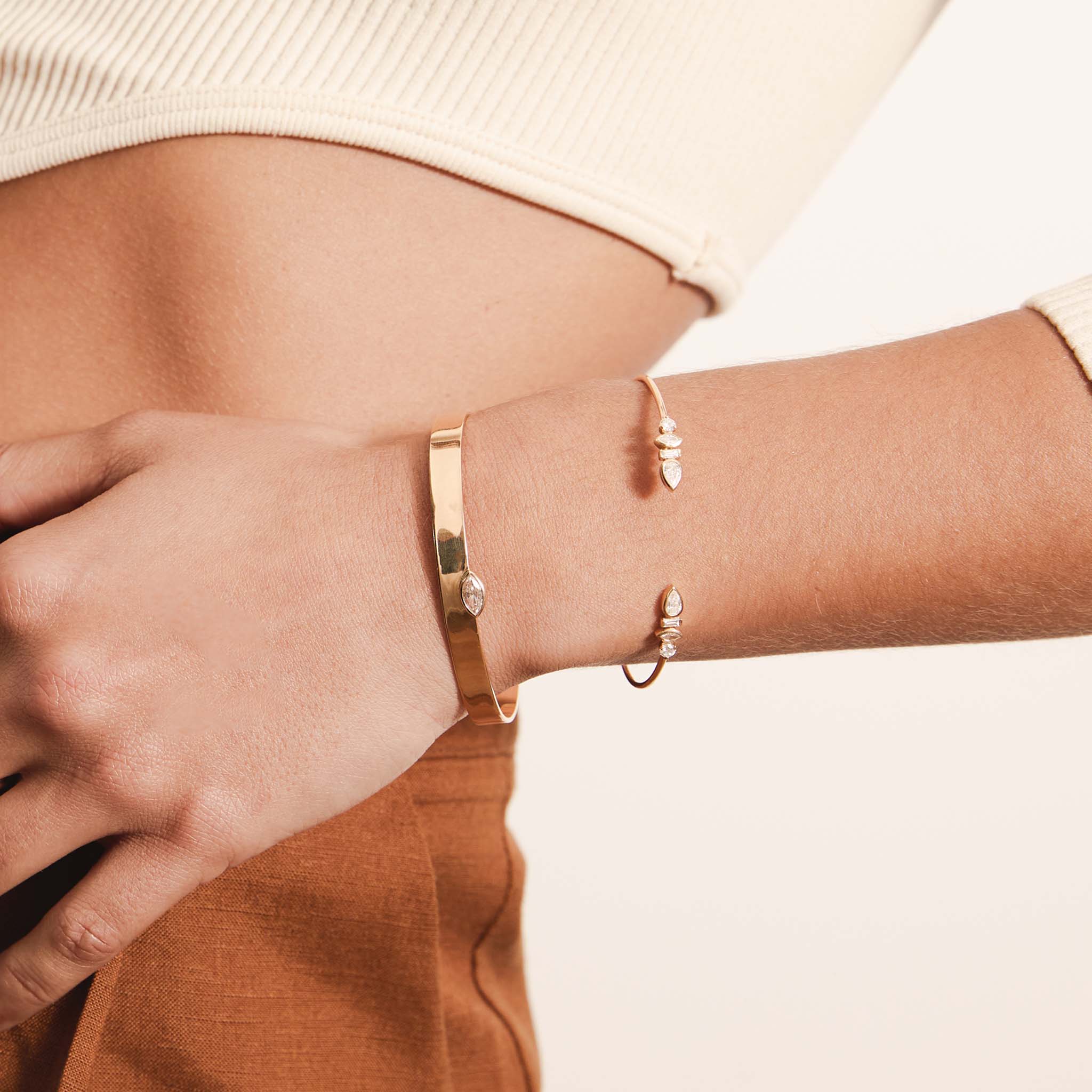 woman resting her hand on her waist wearing a Zoë Chicco 14k Gold Marquise Diamond Flat Wide Cuff Bracelet stacked with a 14k Mixed Fancy Cut Diamond Cuff Bracelet on her wrist