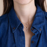 woman in a denim shirt wearing a Zoë Chicco 14k Gold Marquise Diamond Bead Pendant Necklace layered with a 14k Pear Diamond Bead Pendant Necklace and a 14k Prong Heart Shaped Diamond Necklace