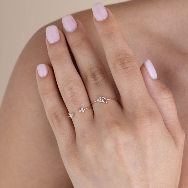 woman resting her hand on her shoulder wearing a Zoë Chicco 14k Gold Marquise Pink Sapphire & Prong Diamond Trio Ring on her middle finger and a Prong Diamond Trio Open Ring on her ring finger