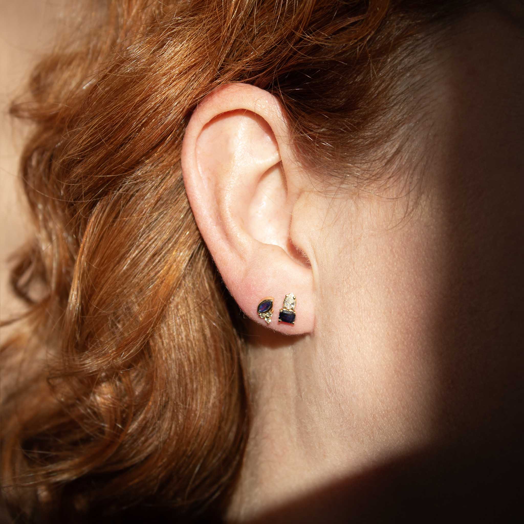 close up of a woman's ear wearing a single Zoë Chicco 14k Gold Marquise Blue Sapphire & Diamond Trio Stud Earring in her second piercing