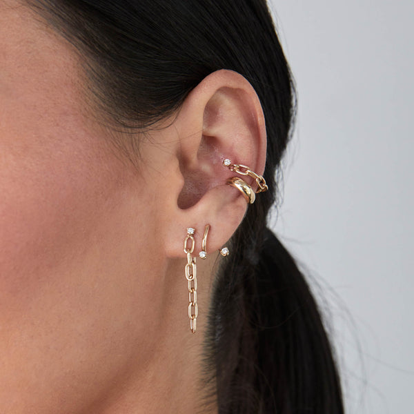 close up of a woman's ear wearing a Zoë Chicco 14k Gold Prong Diamond Medium Square Oval Chain Double Drop Earring layered with a 14k Prong Diamond Curved Bar Drop & Jacket Earring in her second piercing