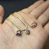 a woman's palm holding a Zoë Chicco 14k Gold One of a Kind Marquise Pink Sapphire with Floating Diamond Stations Necklace