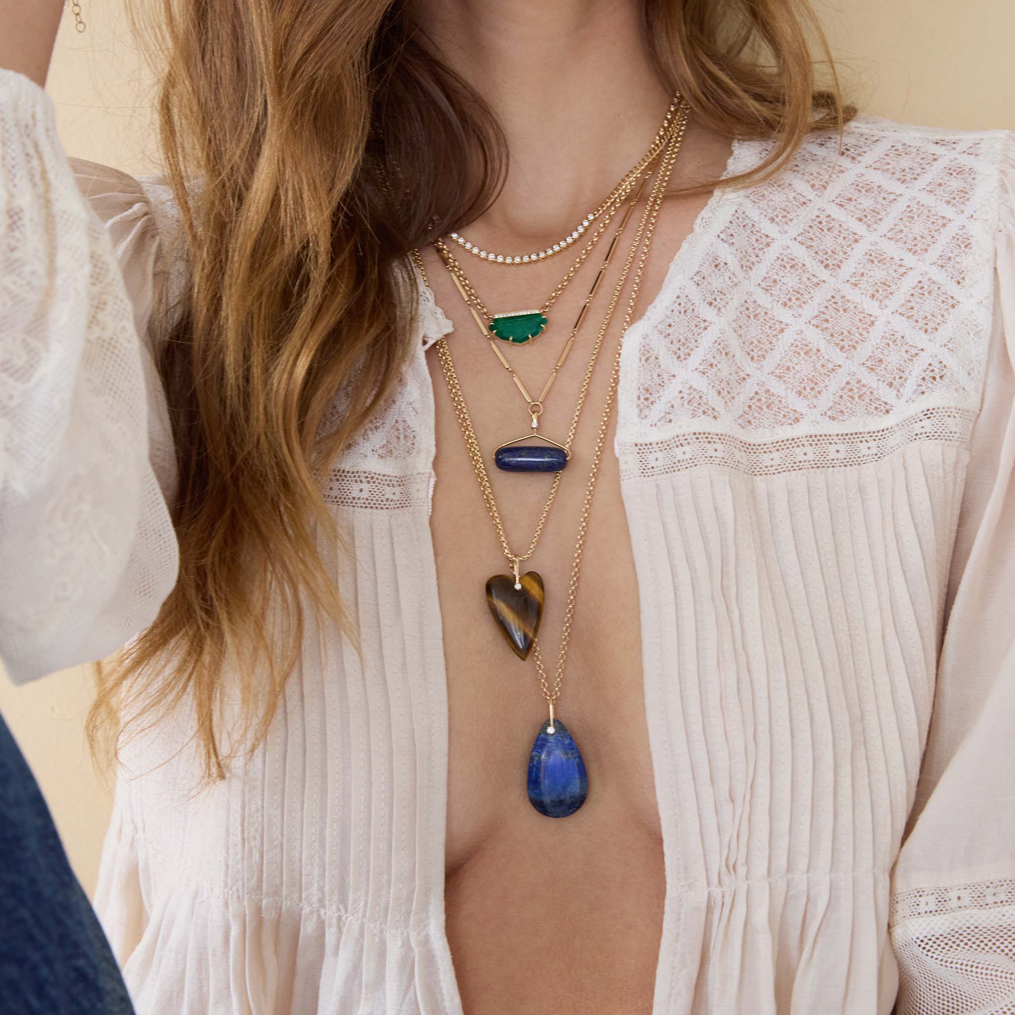 Close-up of a person wearing multiple necklaces with pendants on a light background featuring Zoe Chicco Lapis Roller Bead Pendant 14K Gold Linked Bar Necklace
