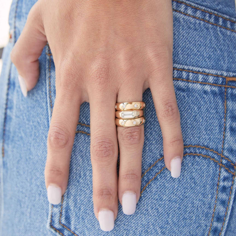 a close up of a woman's hand wearing two Zoë Chicco 14k Gold Half Round Ring with 8 Star Set Diamonds stacked together with a one of a kind baguette diamond ring