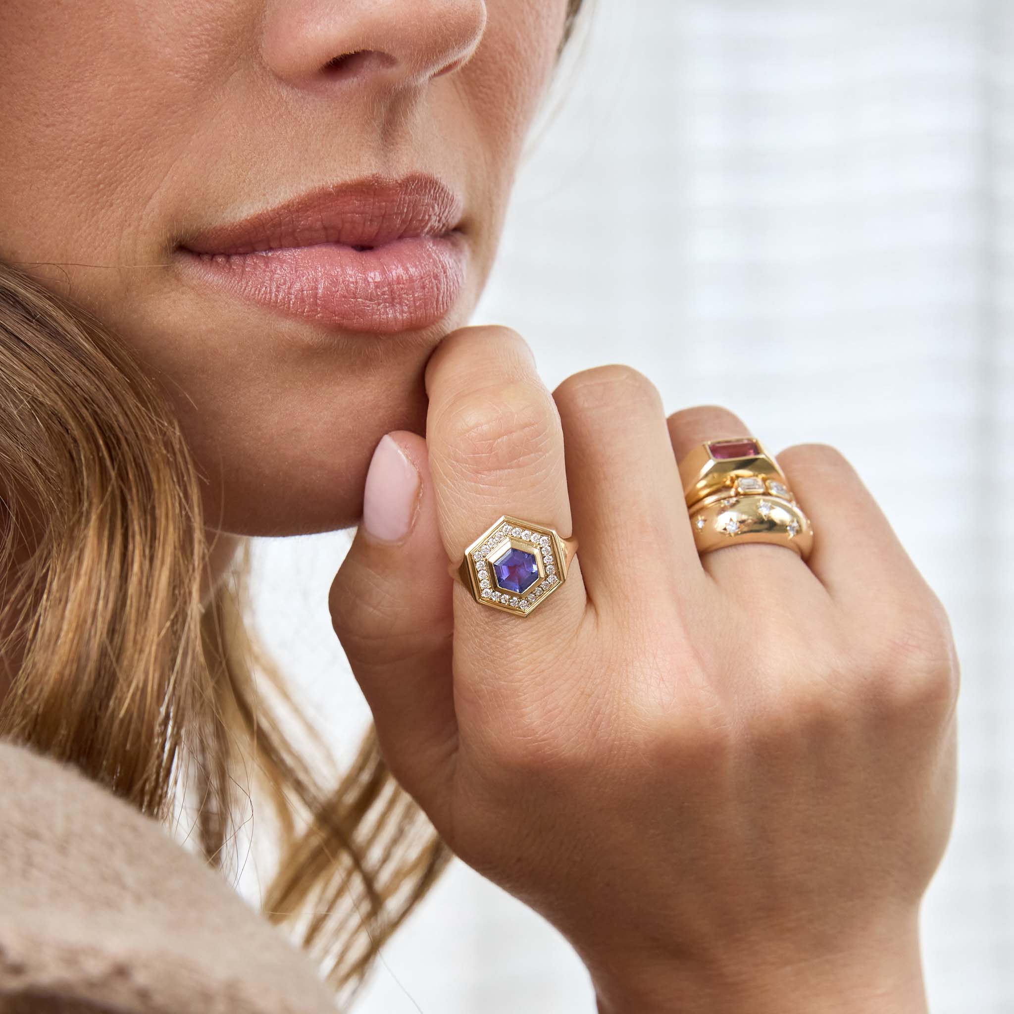 Zoe Chicco 14K Gold blue and pink sapphire rings on a womans hand with a white background 