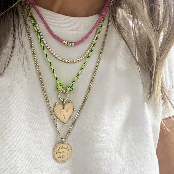 woman in a white tshirt wearing a Zoë Chicco 14k 5mm Gold & Diamond Rondelle Bead Paracord Necklace in Pink Blue layered with a 14k Round Enhancer Paracord Necklace in Neon Green Black and two other gold and diamond necklaces