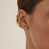 Zoe Chicco 14K  Close-up of an ear wearing a gold earring with a plain background