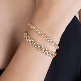 woman in a black top wearing a Zoë Chicco 14k Gold Medium Panther Chain Bracelet stacked with a Small Panther Chain Bracelet