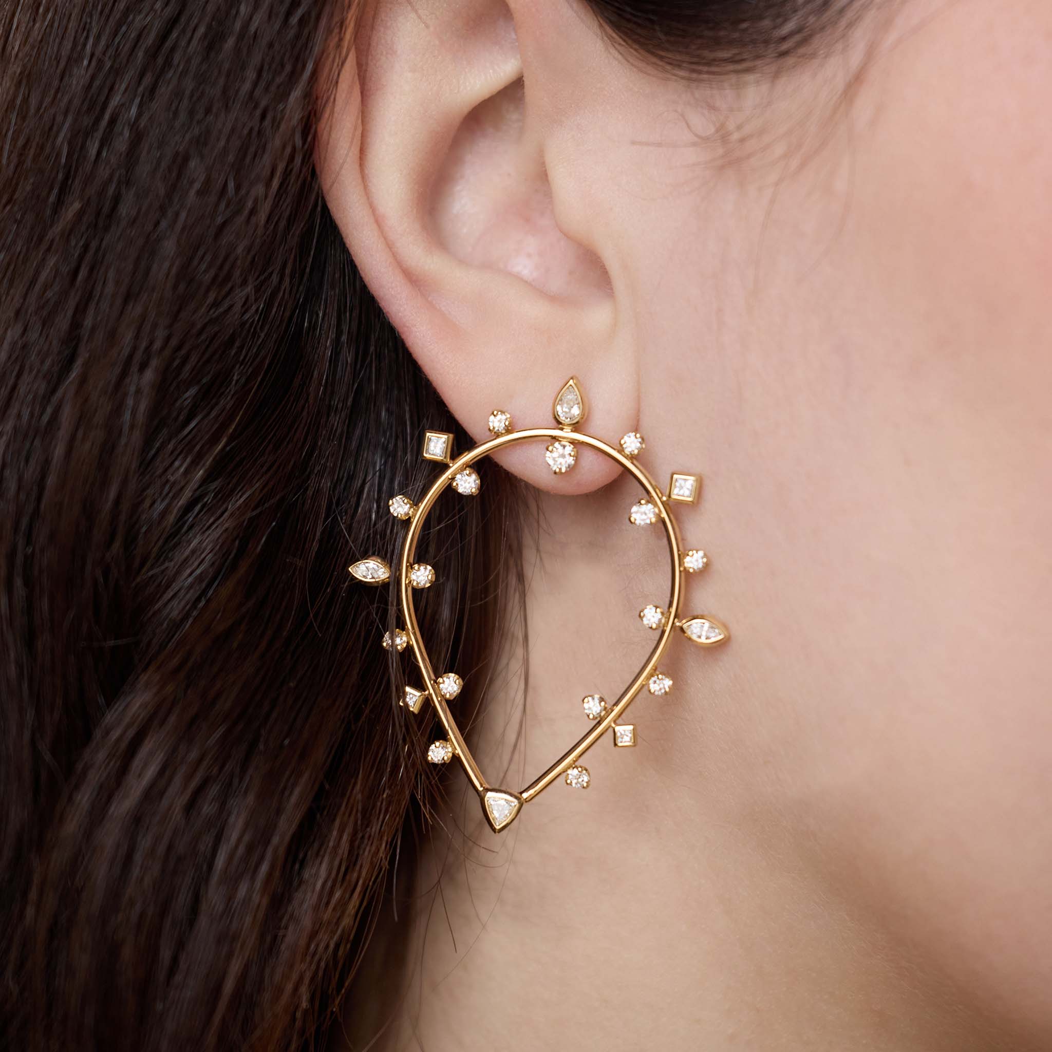Close up of ear wearing Zoë  Chicco 14k Gold Mixed Diamond Upside Down Teardrop Earrings on a dark background