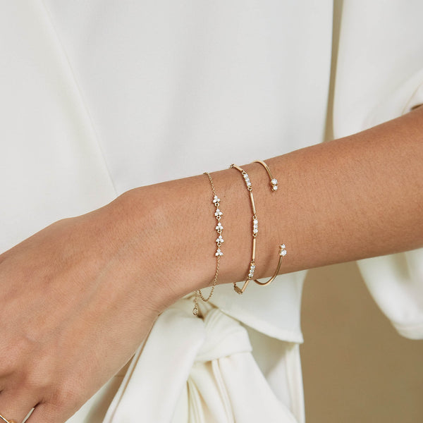 close up of a woman's wrist wearing a Zoë Chicco 14k Gold 5 Linked Diamond Trio Bracelet layered with two bracelets