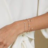 a woman's wrist wearing a Zoë Chicco 14k Mixed Gold & Diamond Bar Bracelet stacked with two other bracelets