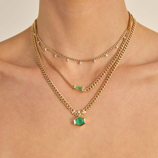 Zoe Chicco 14K Gold necklaces with emerald stones and diamonds on a woman's neck