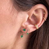 close up of woman's ear wearing a Zoë Chicco 14k Gold Prong Emerald & Short Diamond Tennis Drop Earring on her second piercing with a 14k Emerald Cut Emerald Stud & Pear Emerald Jacket Earring and a Chubby Half Round Ear Cuff