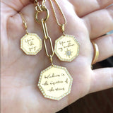 woman holding a Zoë Chicco 14k Gold Large "Kindness is the signature of the strong" Pavé Diamond Octagon Mantra Clip On Charm Pendant on a lariat chain in her palm with two other mantra pendants