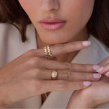 woman with her hand resting under her chin wearing a Zoë Chicco 14k Gold San Marco Band Ring on her index finger and a one of a kind Oval Diamond Signet Ring on her ring finger