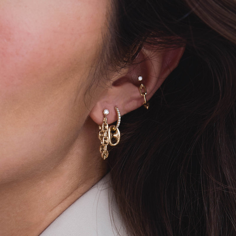 woman's ear wearing a Zoë Chicco 14k Gold Prong Diamond Small Mariner Chain Huggie Earring and a 14k Dangling Large Mariner Link Medium Pavé Diamond Hinge Huggie Hoop in her second piercing layered with a Prong Diamond Square Oval Chain Ear Cuff