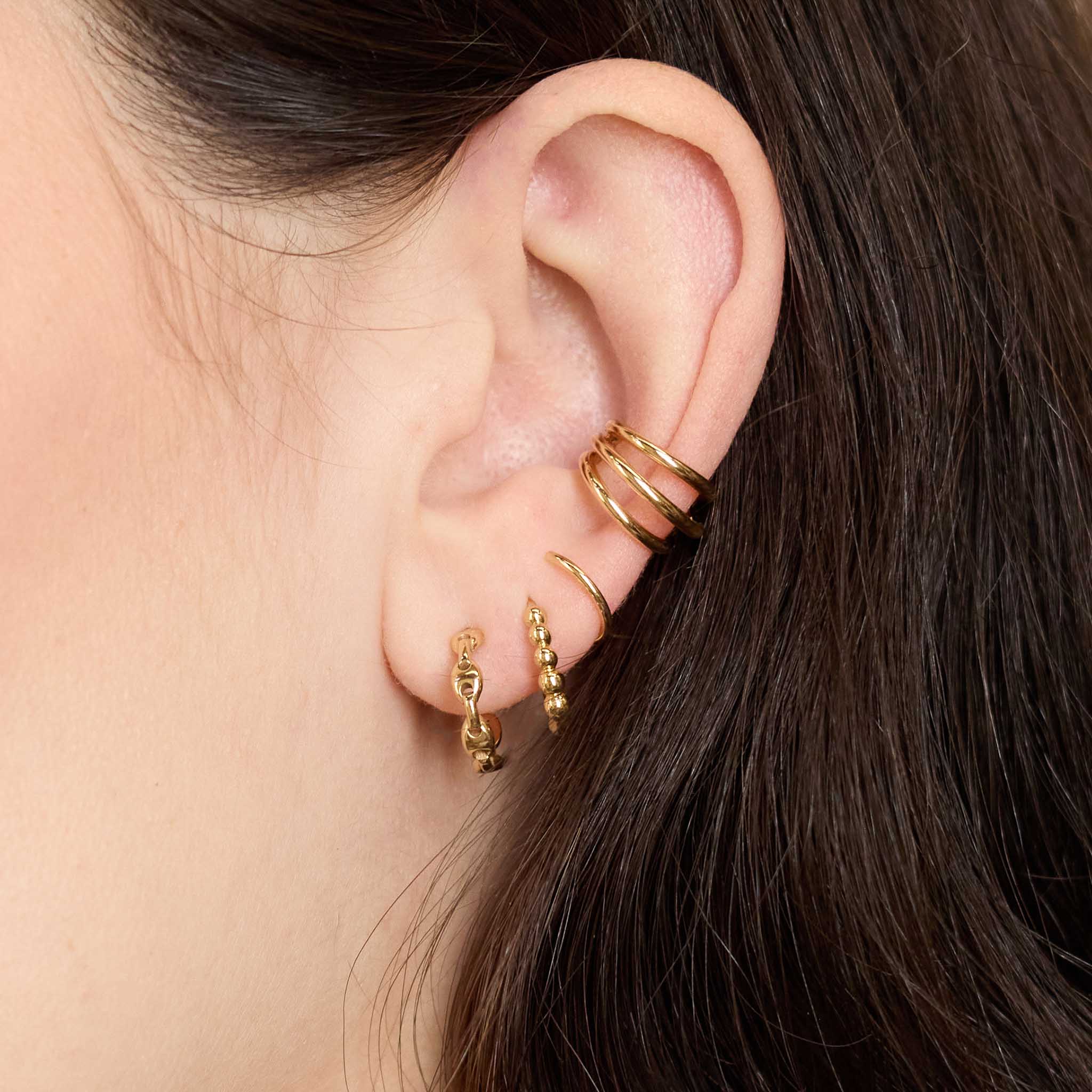 Close up of ear wearing multiple Zoe Chicco 14k gold hoop earrings