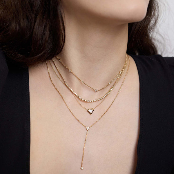 Zoe Chicco 14K multiple gold necklaces with heart pendants worn by a woman
