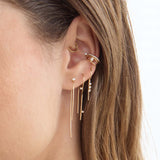 Zoe Chicco 14K  Close-up of an ear with gold earrings on a neutral background