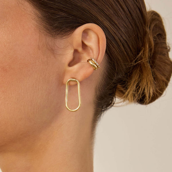 Close up of an ear wearing Zoe Chicco 14k snake chain earrings and cuff earrings
