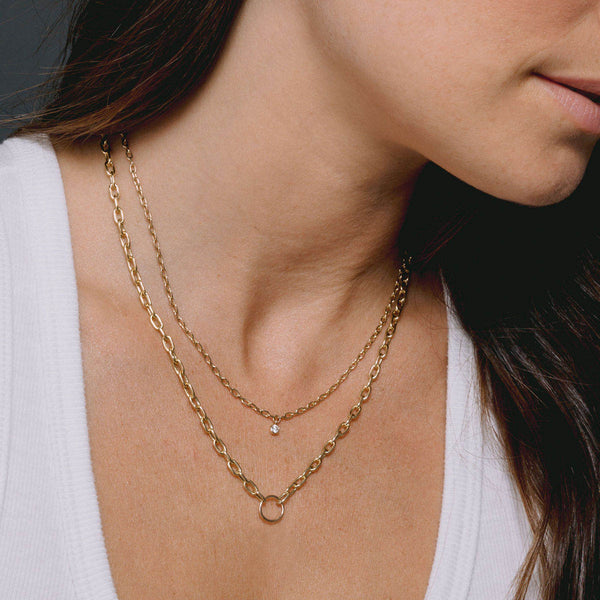 woman in a white top wearing a Zoë Chicco 14k Gold Circle Medium Square Oval Link Chain Necklace layered with a Diamond Bezel Small Square Oval Chain Necklace