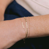 A Zoë Chicco 14k Gold Itty Bitty MAMA Bracelet layered with a Zoë Chicco 14k Gold Itty Bitty MAMA Curb Chain Bracelet