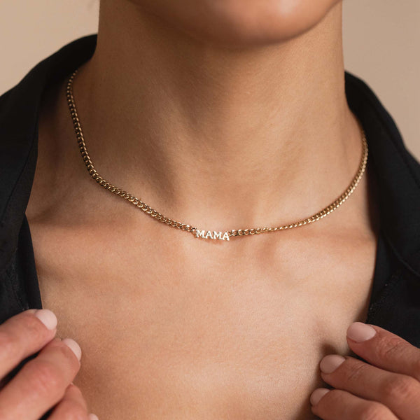 woman in a black shirt wearing a Zoë Chicco 14k Gold Itty Bitty MAMA Small Curb Chain Necklace