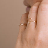 A woman wears the 14k Itty Bitty MAMA Ring on her pinky finger