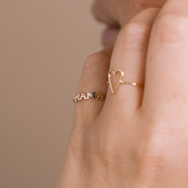 A woman wears the 14k Itty Bitty MAMA Ring on her pinky finger