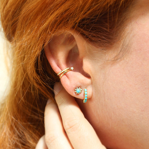woman's ear wearing a Zoë Chicco 14k Gold Prong Turquoise & Diamond Flower Stud Earring in her second piercing