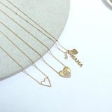 a Zoë Chicco 14k Gold Pavé Diamond Initial Letter G Small Heart Necklace laying flat with two other necklaces