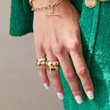 woman's hand wearing a Zoë Chicco 14k Gold Graduating Star Set Diamonds Medium Aura Ring stacked with a one of a kind emerald baguette ring