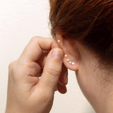 A view from behind a woman's ear wearing Zoë Chicco 14k gold flat back stud earrings