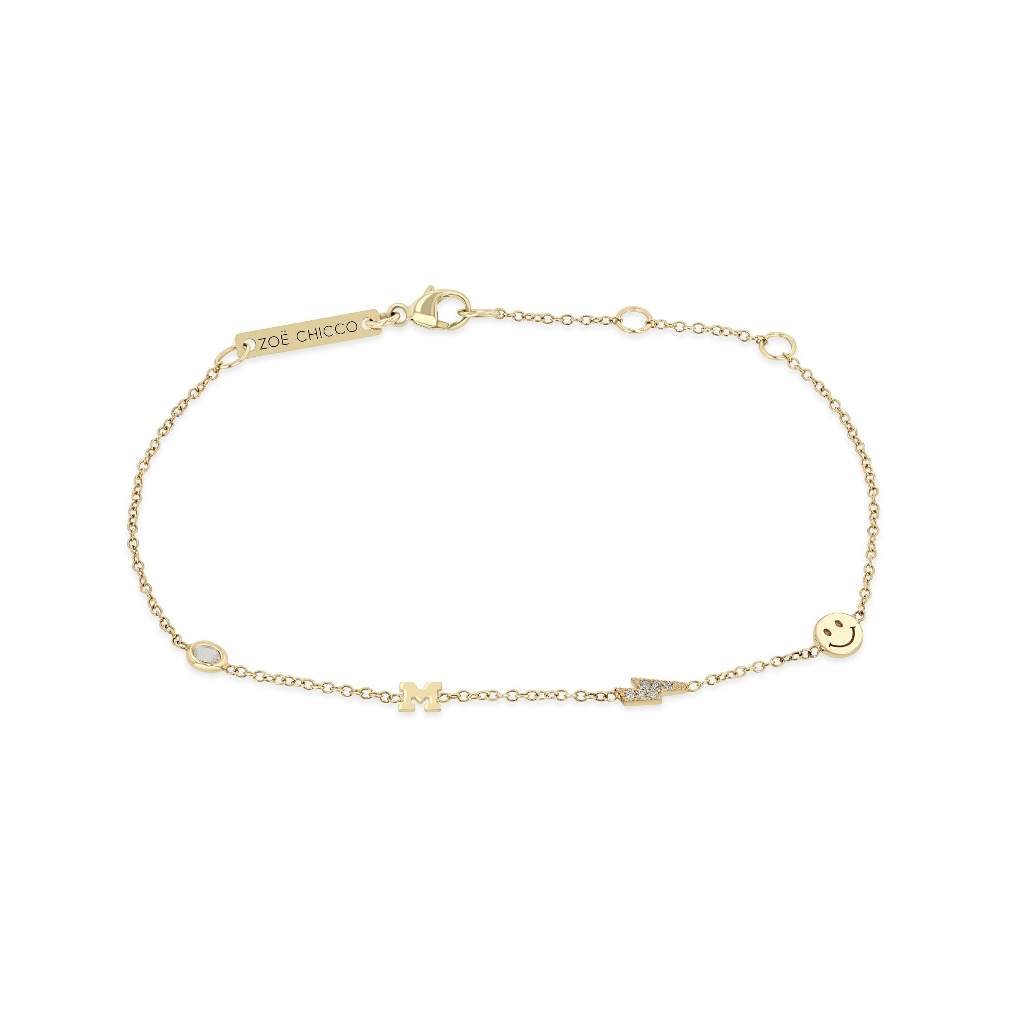 a picture of a 14k Gold Custom Heartstrings Bracelet with a moonstone, letter M, pavé diamond lightning bolt, and a smiley face