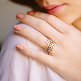 woman's hand resting on shoulder wearing a stack of Zoe Chicco 14 karat gold diamond bezel rings on her fourth finger