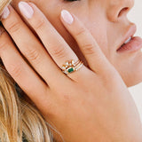 close up of woman's hand resting against her face wearing a Zoë Chicco 14k Gold Emerald Cut Emerald Bezel Pavé Diamond Band Ring on her ring finger stacked with two diamond rings