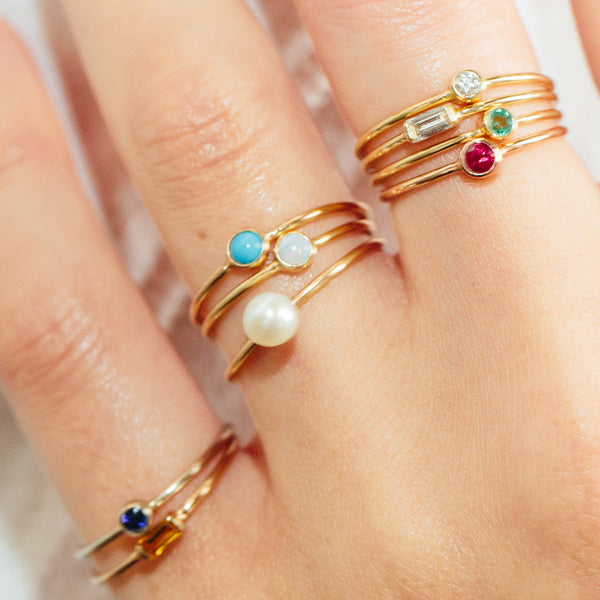 close up of hand wearing Zoe Chicco 14kt Gold Small Pearl Ring | June Birthstone with other birthstone rings