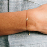 woman's wrist wearing Zoe Chicco 14kt Gold Floating Pear Diamond Bolo Bracelet