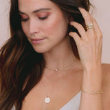 brunette woman with hand raised to head wearing Zoë Chicco 14k Gold Floating Diamond Mixed Small Curb & Med Square Oval Chain Necklace on her neck