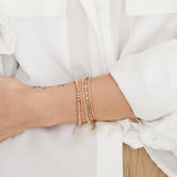 woman in white button down shirt wearing a Zoë Chicco 14k Gold Marquise Diamond Cuff & Medium Rope Chain Double Bracelet layered with a gold bead bracelet on her wrist