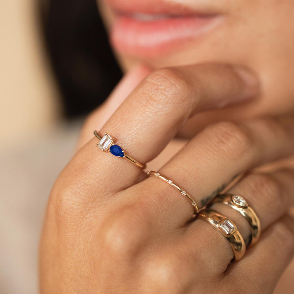 close up of woman's hand wearing a Zoë Chicco 14k Gold Pear Blue Sapphire & Emerald Cut Diamond Ring