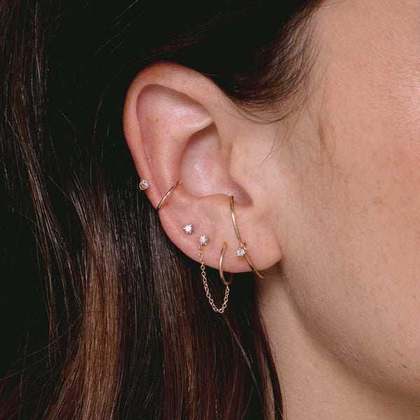 close up of woman's ear wearing Zoë Chicco 14k Gold Prong Diamond Stud & Huggie Hoop Linked Double Earring